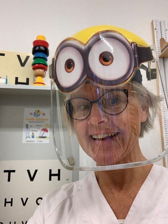 Barnhälsovårdsöverläkare Ylva Tindberg  har på sig ett skyddsvisir där hon har klistrat på figurerna Minionernas ögon längst upp på visiret.