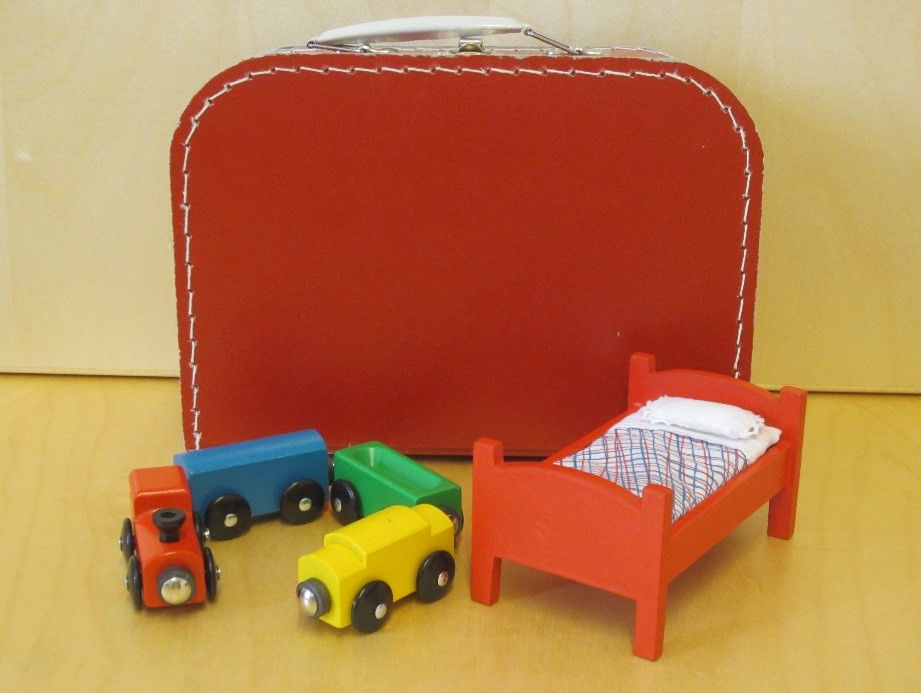 Leksakslok med tre vagnar och en leksakssäng. Bild.